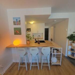 a kitchen with a counter with four stools around it at Warm & cozy loft full of light, Ski-in Ski-out in Stoneham