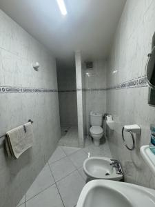 a white bathroom with a toilet and a sink at Hôtel Résidence Louban in Agadir +10 photos
