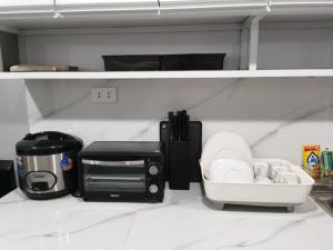 a kitchen counter with a coffee maker and a toaster at Samong Transient House in Imus