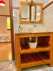 ein Badezimmer mit Waschbecken und Spiegel in der Unterkunft Casa COMPLETA, 2 quartos, Estacionamento GRATUITO, WIFI 300MB, frigobar, microondas, fogão e jardim in São João del Rei