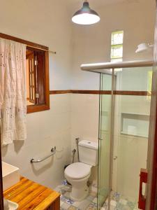 ein Badezimmer mit Toilette und Glasdusche in der Unterkunft Casa COMPLETA, 2 quartos, Estacionamento GRATUITO, WIFI 300MB, frigobar, microondas, fogão e jardim in São João del Rei + 8 Fotos