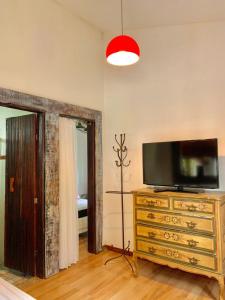 ein Schlafzimmer mit einer Kommode und einem TV darüber in der Unterkunft Casa COMPLETA, 2 quartos, Estacionamento GRATUITO, WIFI 300MB, frigobar, microondas, fogão e jardim in São João del Rei