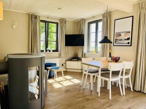 Ferienhaus Huus Waterkant 18 Feriendorf Klein Stresow Rügen by ruyastay في بوتبوس: غرفة معيشة مع طاولة وغرفة طعام
