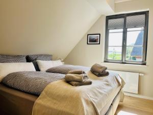 Ferienhaus Huus Waterkant 18 Feriendorf Klein Stresow Rügen by ruyastay في بوتبوس: غرفة نوم بها سرير مع مناشف عليه