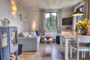 a living room with a couch and a table at Ferienhaus Große Lage 16 Feriendorf Klein Stresow Rügen by ruyastay in Putbus