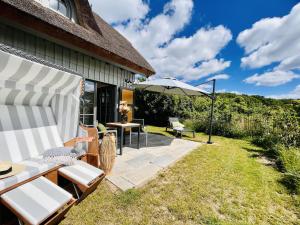 Ferienhaus Mein Ankerplatz 17 Feriendorf Klein Stresow Rügen by ruyastay في بوتبوس: فناء مع طاولة وكراسي ومظلة