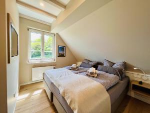een slaapkamer met een bed met twee handdoeken erop bij Ferienhaus Reetblick 23 Feriendorf Klein Stresow Rügen by ruyastay in Putbus