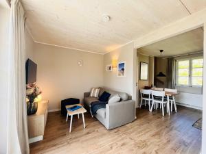 Ferienhaus Boddenlust 24 Feriendorf Klein Stresow Rügen by ruyastay في بوتبوس: غرفة معيشة بها أريكة وطاولة