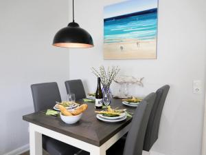 a dining room table with chairs and a table with food at Andreas-Nielsen-Str. 12, W2 in Westerland (Sylt)