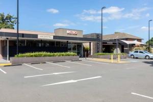 a parking lot in front of a shopping center at Riverwood Hotel - Adults Only in Riverwood