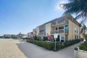 - un bâtiment sur la plage avec un palmier dans l'établissement Bayfront Condo in Mission Beach, à San Diego