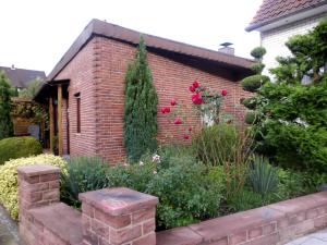 
a garden with flowers and plants in front of a brick building at Ferienwohnung Hoffmann in Bad Münder am Deister
