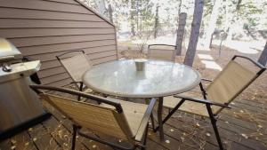 a table and chairs on a porch with a coffee cup on it at Skyline Condo 02 in Sunriver