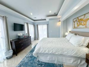 Un dormitorio con una cama grande y un televisor. en 3br Gem Skyline Views, Laundry & Central Air, en Boston