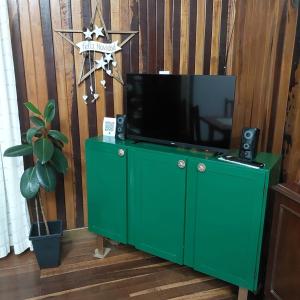 a green entertainment center with a television on top at La esquina in Dos de Mayo