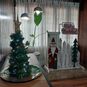 a table with a christmas tree and a christmas sign at La esquina in Dos de Mayo