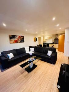 een woonkamer met een zwarte bank en een tafel bij Scotapartments in Edinburgh