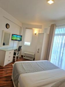 ヌワラエリヤにあるTHE WIND LILY - Lake View Luxury Apartmentのベッドと机とテレビのある寝室 +51枚の写真