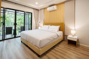 a bedroom with a bed and a large window at T House in Bang Tao Beach