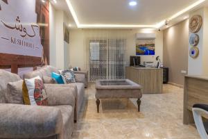 Kush Hotel, Grand Museum & Pyramids View في القاهرة: غرفة معيشة مع كنب وطاولة قهوة