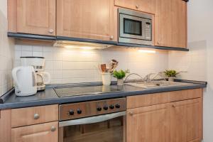 eine Küche mit Spüle und Mikrowelle in der Unterkunft Dünenresidenz 13 in Zinnowitz + 6 Fotos