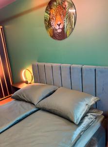 a bedroom with a bed with a clock on the wall at Jacuzzi Jungle Apartments in Malbork