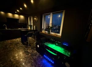 a bathroom with a tub with green water in it at Jacuzzi Jungle Apartments in Malbork