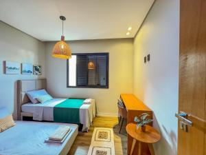 ein kleines Zimmer mit zwei Betten und einem Fenster in der Unterkunft Casa Bela - Centro in Águas de Lindóia