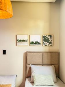 ein Schlafzimmer mit drei Bildern an der Wand über einem Bett in der Unterkunft Casa Bela - Centro in Águas de Lindóia + 53 Fotos