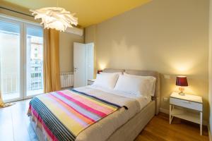 Un dormitorio con una cama y una ventana grande. en ALMA SUN ROOMS Testaccio Heart of Rome, en Roma