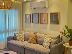 ein Wohnzimmer mit einem Sofa und Kissen in der Unterkunft Casa Bela - Centro - Ar condicionado Garagem Wi-fi in Águas de Lindóia