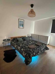 a bedroom with a bed and two tables in it at Jacuzzi & Sauna privatifs - Vue mer in Blainville-sur-Mer