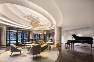 a living room with a piano and a couch at Home2 Suite by Hilton Harbin Central Street in Harbin