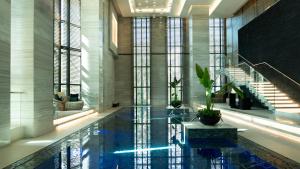 a swimming pool in a building with a staircase at Fairmont Riyadh in Riyadh