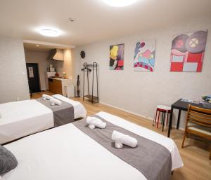 een hotelkamer met 3 bedden, een tafel en een keuken bij OASIS NANIWA in Osaka +74 foto's