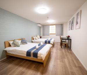 een hotelkamer met twee bedden en een bureau bij OASIS NANIWA in Osaka