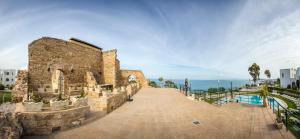 迦玛特Golden Carthage Residences的海边有一条步道的石头建筑 更多22张照片