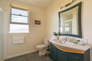 a bathroom with a sink and a toilet and a mirror at Olive's Cottage and Gardens - Mesmerising Views in Windermere