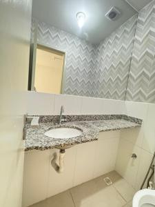 a bathroom with a sink and a mirror at Casa brisa do mar 2 in Arraial do Cabo +8 photos