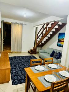 a living room with a table and a couch at Casa brisa do mar 2 in Arraial do Cabo