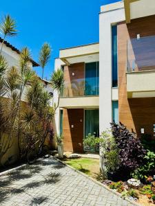 a house with palm trees in front of it at Casa brisa do mar 2 in Arraial do Cabo