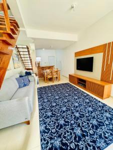 a living room with a couch and a tv at Casa brisa do mar 2 in Arraial do Cabo