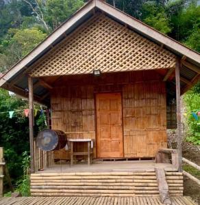 a small hut with a table and a wooden door at Baruk Mas Kampung Assum in Kuching