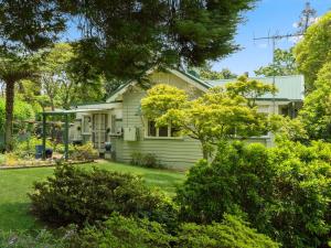 a yellow house with a yard at Westlee Cottage in Wentworth Falls