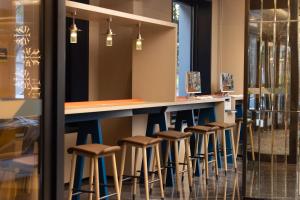 a row of stools at a bar in a restaurant at Home2 Suite by Hilton Harbin Central Street in Harbin