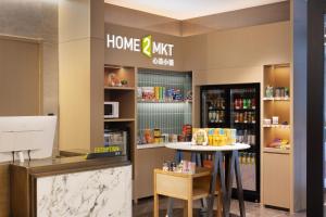 a home appliance store with a table and a counter at Home2 Suite by Hilton Harbin Central Street in Harbin