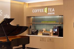 a coffee shop with a piano and a coffee machine at Home2 Suite by Hilton Harbin Central Street in Harbin