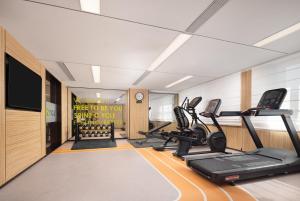 a gym with treadmills and ellipticals in a room at Home2 Suite by Hilton Harbin Central Street in Harbin