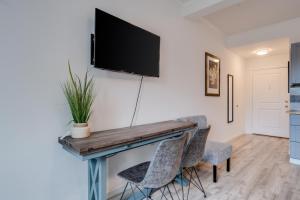 a dining room with a table with chairs and a tv on the wall at Unit 10 Waena Inn - Maui Private Suite in Wailuku