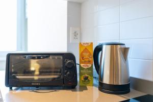 Un horno tostador y una cafetera sobre una encimera. en ALMA SUN ROOMS Testaccio Heart of Rome, en Roma 45 fotos más